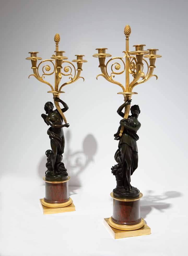 A Pair of three-branch ormolu Candelabra with patinated bronze figures of Zephyrus and Flora, on rouge griotte marble columns